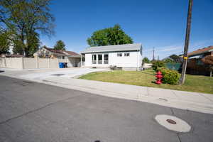 White siding exterior with a light gray roof, front lawn, and concrete driveway