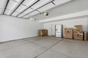 Spacious garage with a concrete floor, white walls, and an overhead garage door opener mechanism