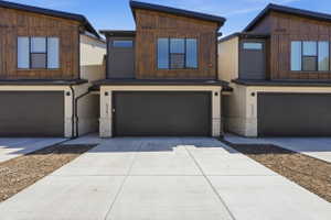 Modern townhome exterior featuring an angular roofline and a dark wood-finish facade