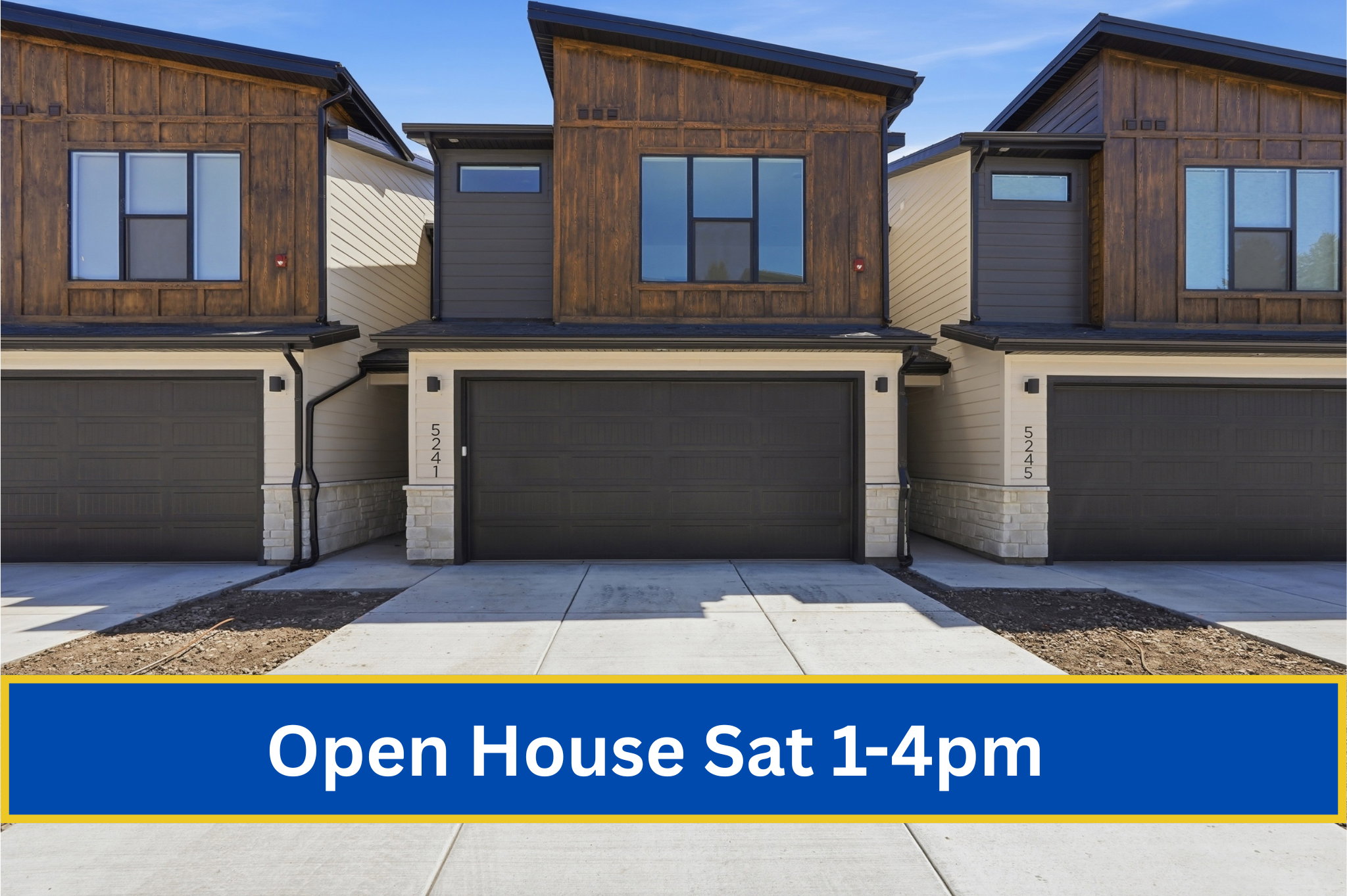 Modern townhome exterior featuring a contrasting material palette, two-car garage, upper-level wood-finish siding, and contemporary window designs