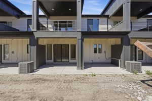 Contemporary multi-level exterior featuring light-colored siding, dark trim, and multiple balconies with metal railings