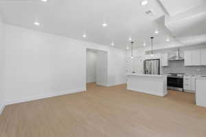 Open-concept living space featuring wood-finish flooring, recessed lighting, and a kitchen island with pendant lighting