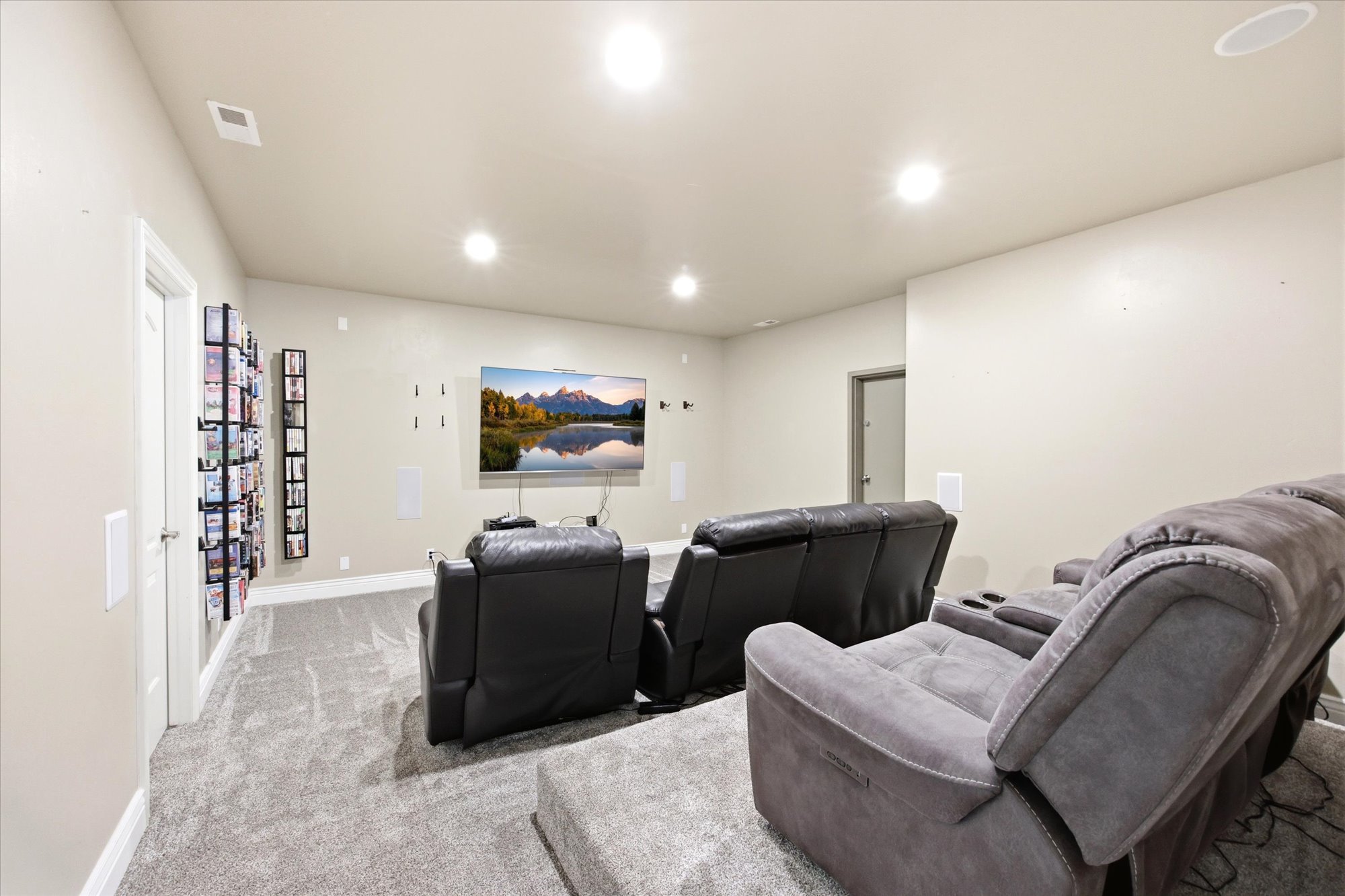 Dedicated entertainment space featuring recessed lighting and wall-mounted speakers