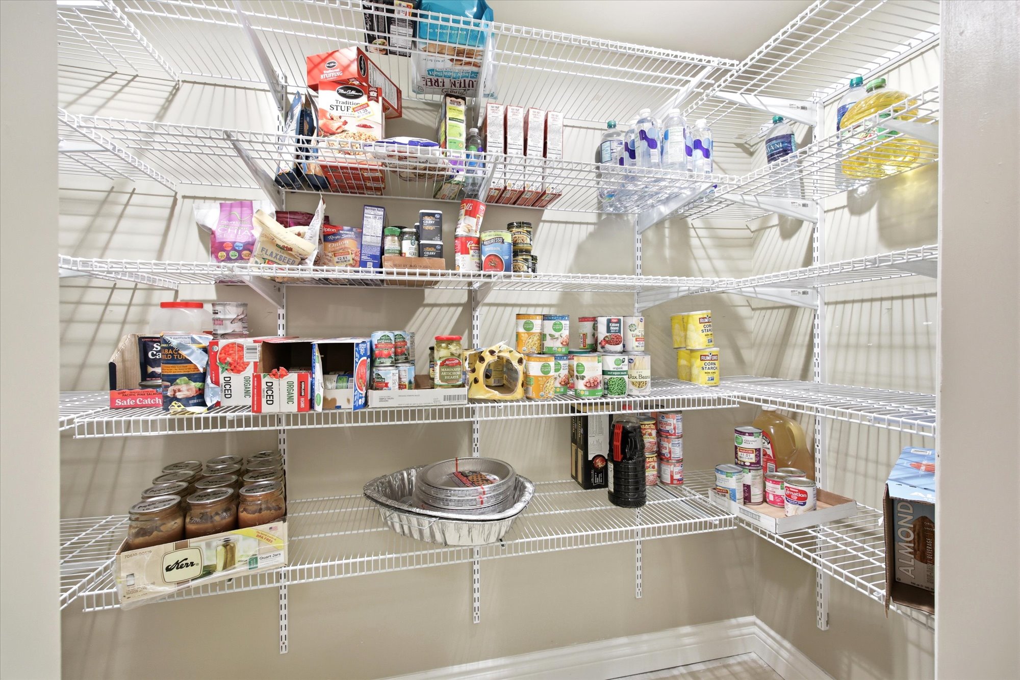 Walk-in pantry featuring extensive wire shelving, multi-level storage, and bright interior lighting