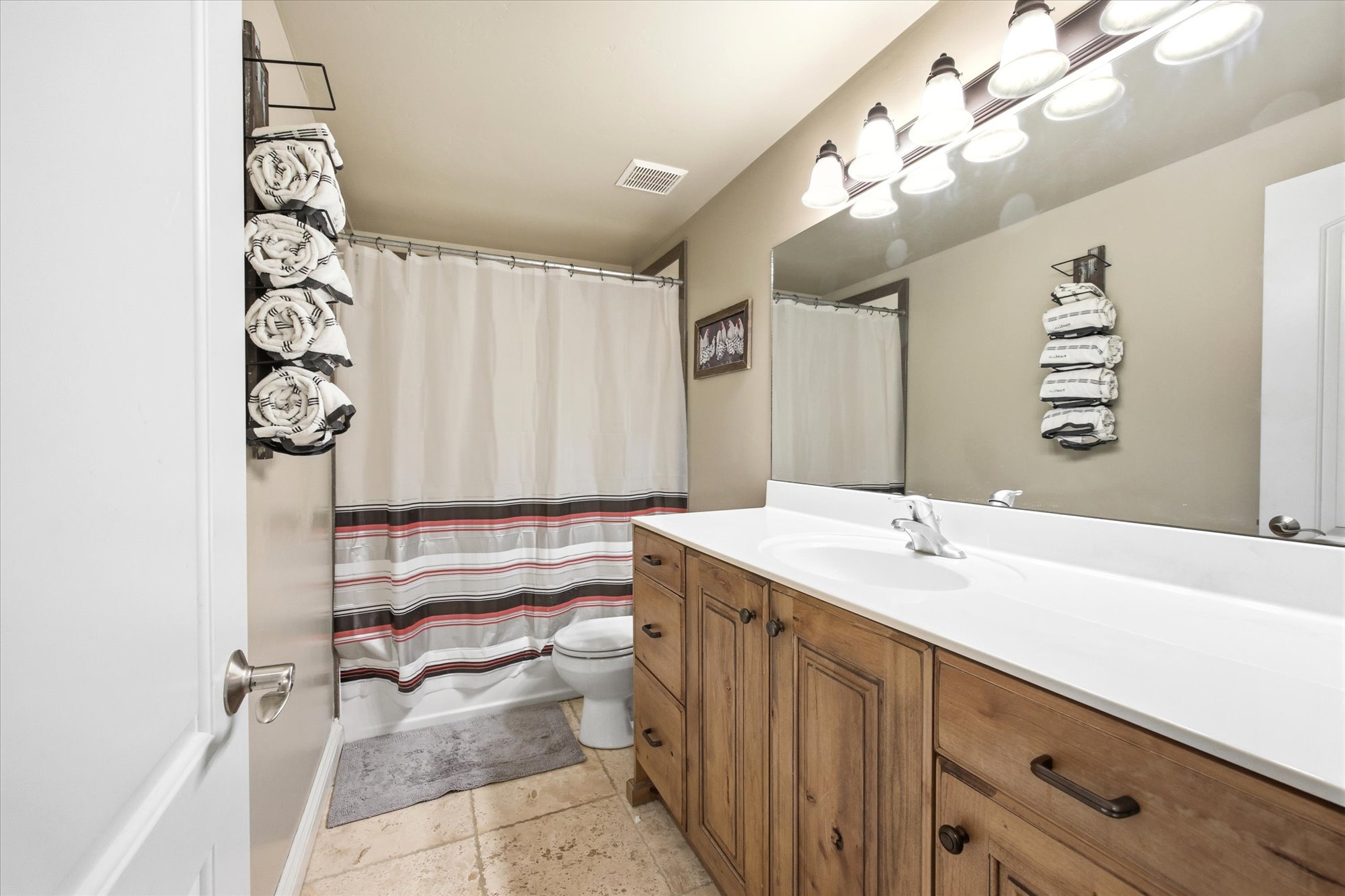 Bathroom featuring a wood-finish vanity with an integrated sink and a white countertop
