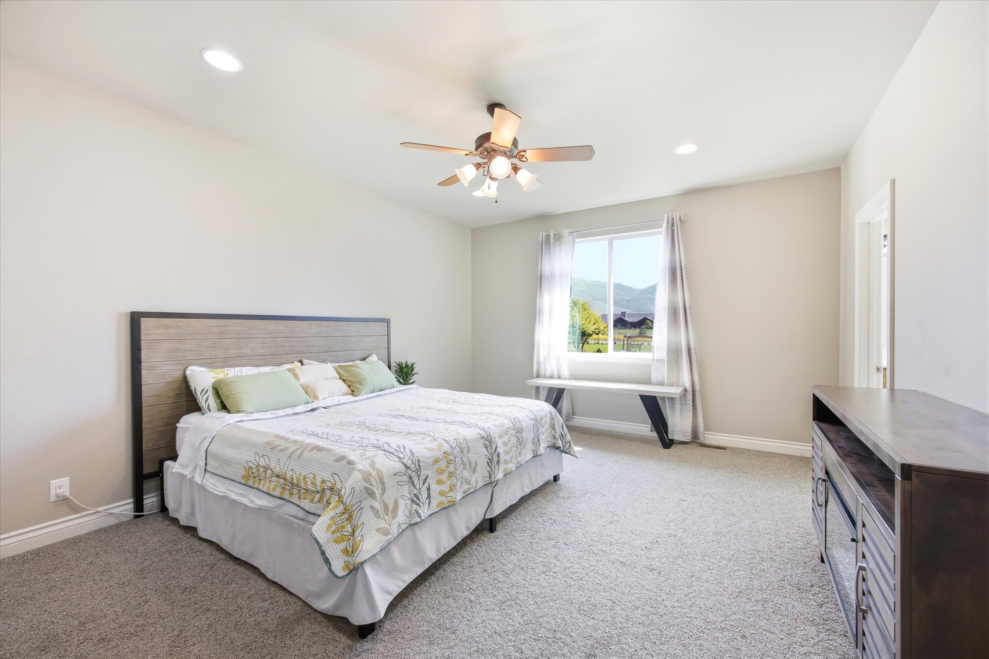 Spacious bedroom featuring plush carpeting, recessed lighting, and a ceiling fan with light fixture