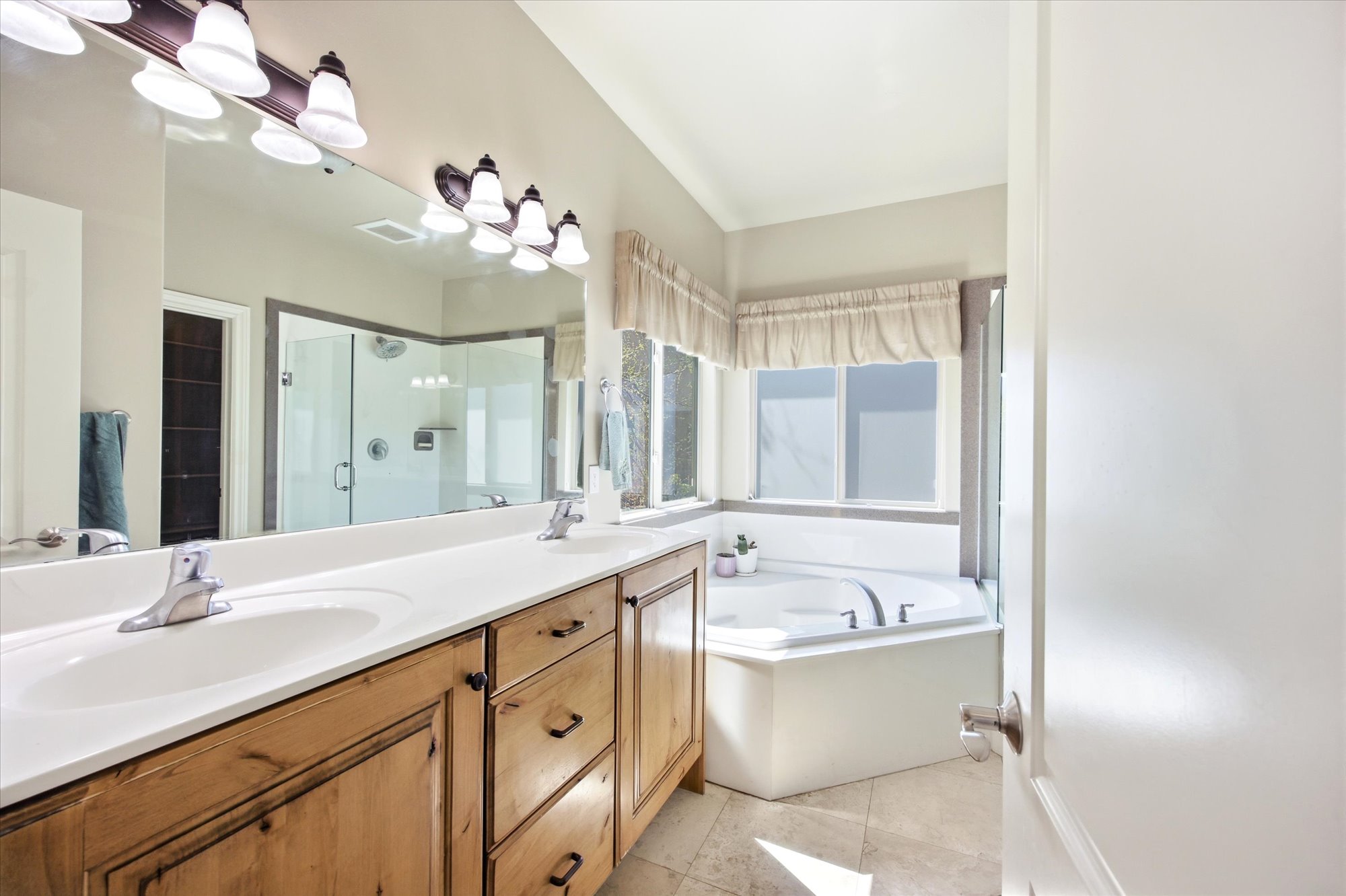 Bathroom with a double vanity featuring wood-finish cabinetry and white countertops