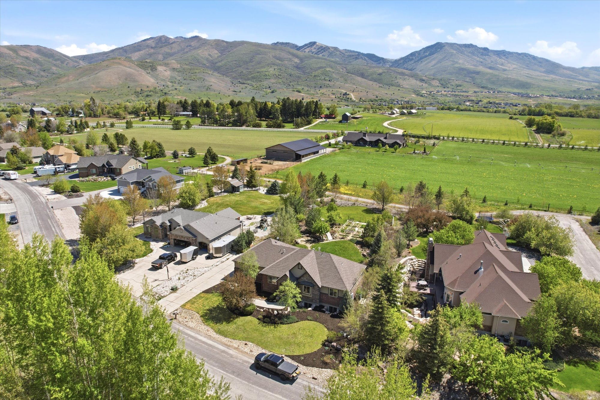 Sprawling property featuring a large residence with a multi-gabled roof, mature landscaping, and a paved driveway