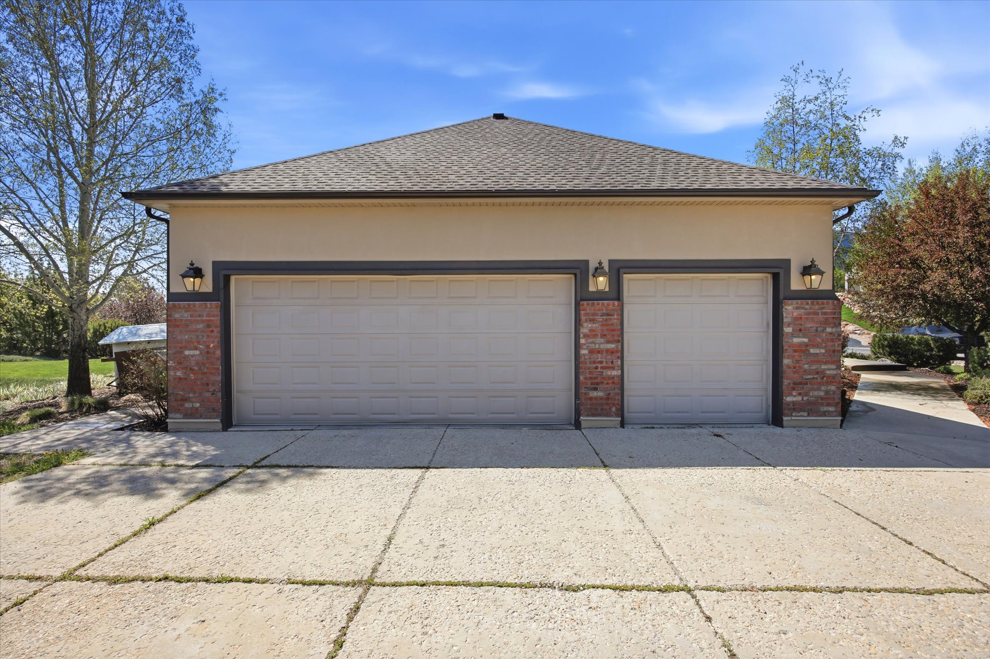 Two-car garage with insulated doors, stucco siding, and brick accents