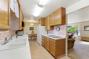 Kitchen featuring wood-finish cabinetry, white countertops, and a mosaic tile backsplash