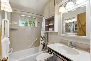 Bathroom featuring a vanity with an integrated sink, a rectangular mirror with overhead vanity lighting, and built-in storage cabinetry