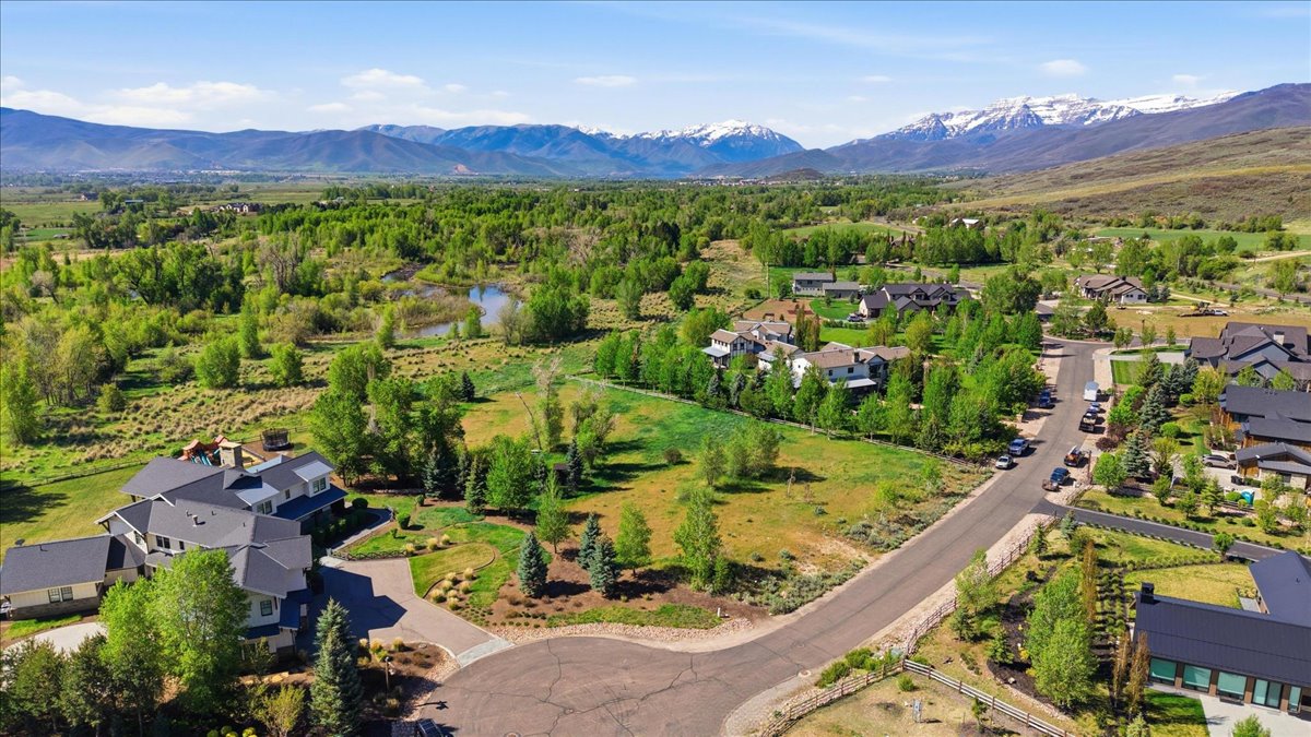 Expansive property featuring a cul-de-sac entrance, mature landscaping, and mountain backdrops