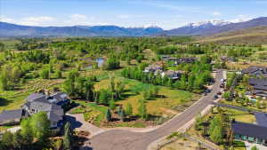 Expansive property featuring a cul-de-sac entrance, mature landscaping, and mountain backdrops