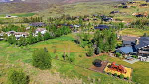 Expansive property featuring a large green space, established trees, and a distant mountain backdrop