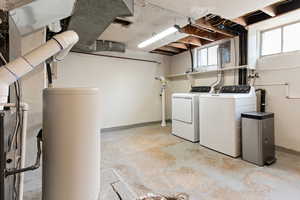 Utility space featuring a washer, dryer, water heater, and exposed ceiling joists
