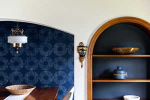 Built-in arched wooden shelving unit featuring dark backing and wooden shelves