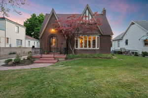 Brick facade residence featuring a prominent bay window, arched entry, and a pitched roofline