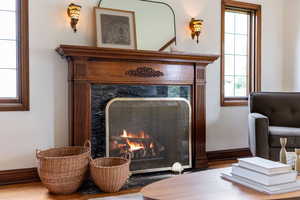 Fireplace featuring a carved wood mantel, black stone surround, and polished brass screen