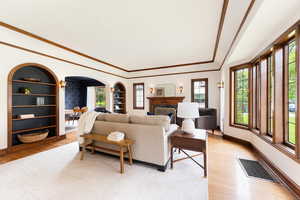Living area with wood-finish flooring and a white area rug