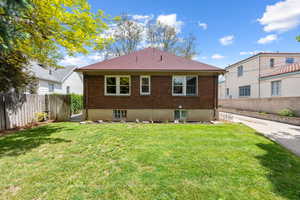 Expansive green lawn bordering a brick exterior with a red shingle roof