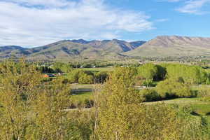 Expansive mountain range backdrop with distant residential structures