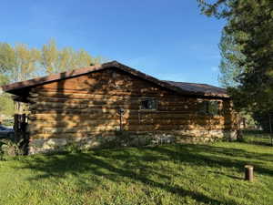 Log cabin exterior featuring a low-pitched roofline and multiple windows