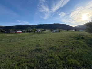 Expansive green pastureland with distant mountain ranges