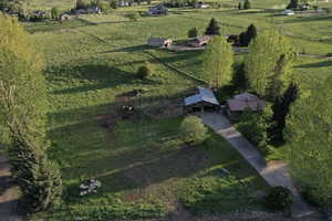 Expansive property featuring a main residence with a brown roof, an adjacent outbuilding with a metal roof, and a paved driveway