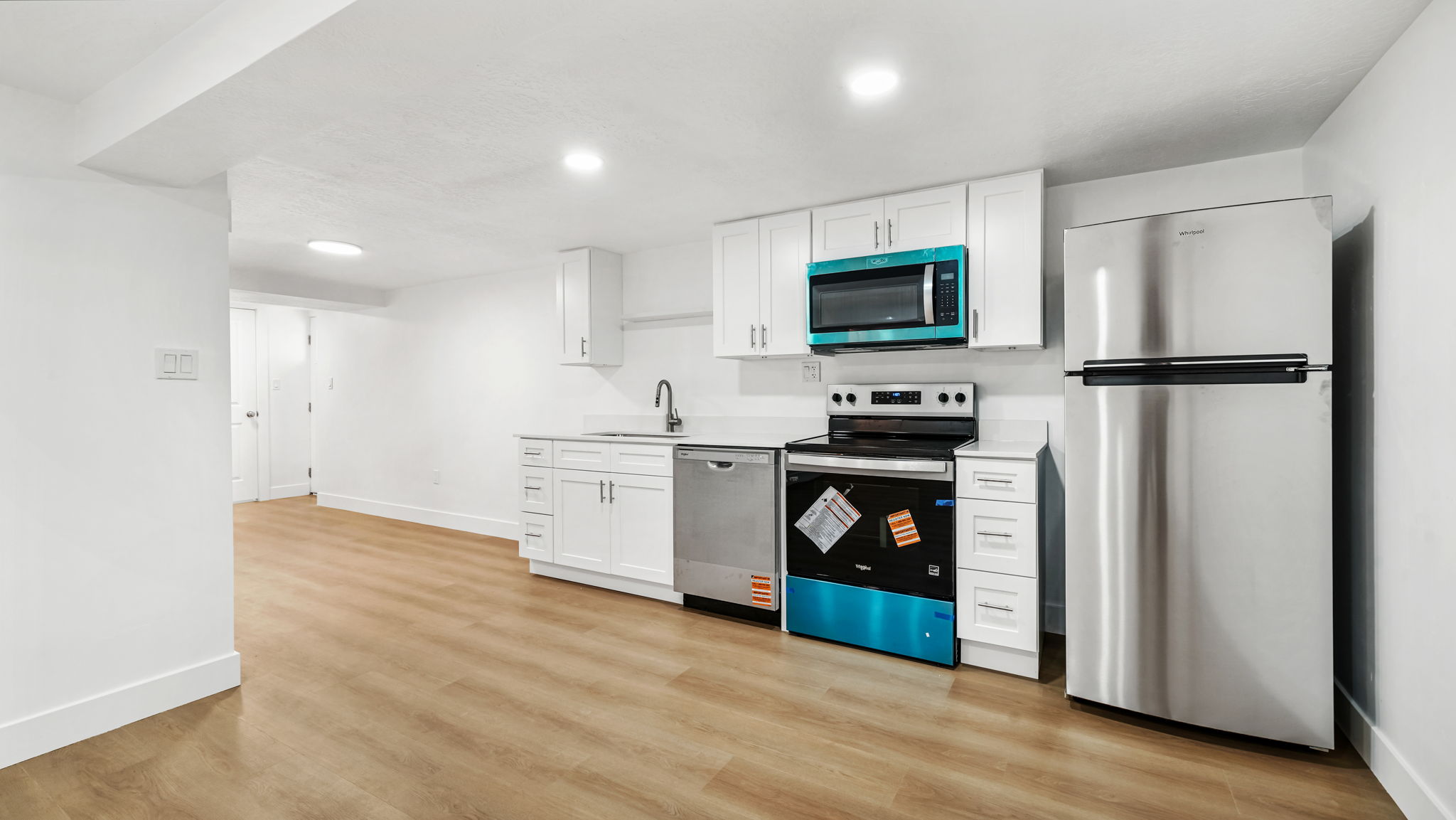 Kitchen featuring white shaker cabinetry, light-toned wood-finish flooring, stainless steel appliances, and recessed lighting