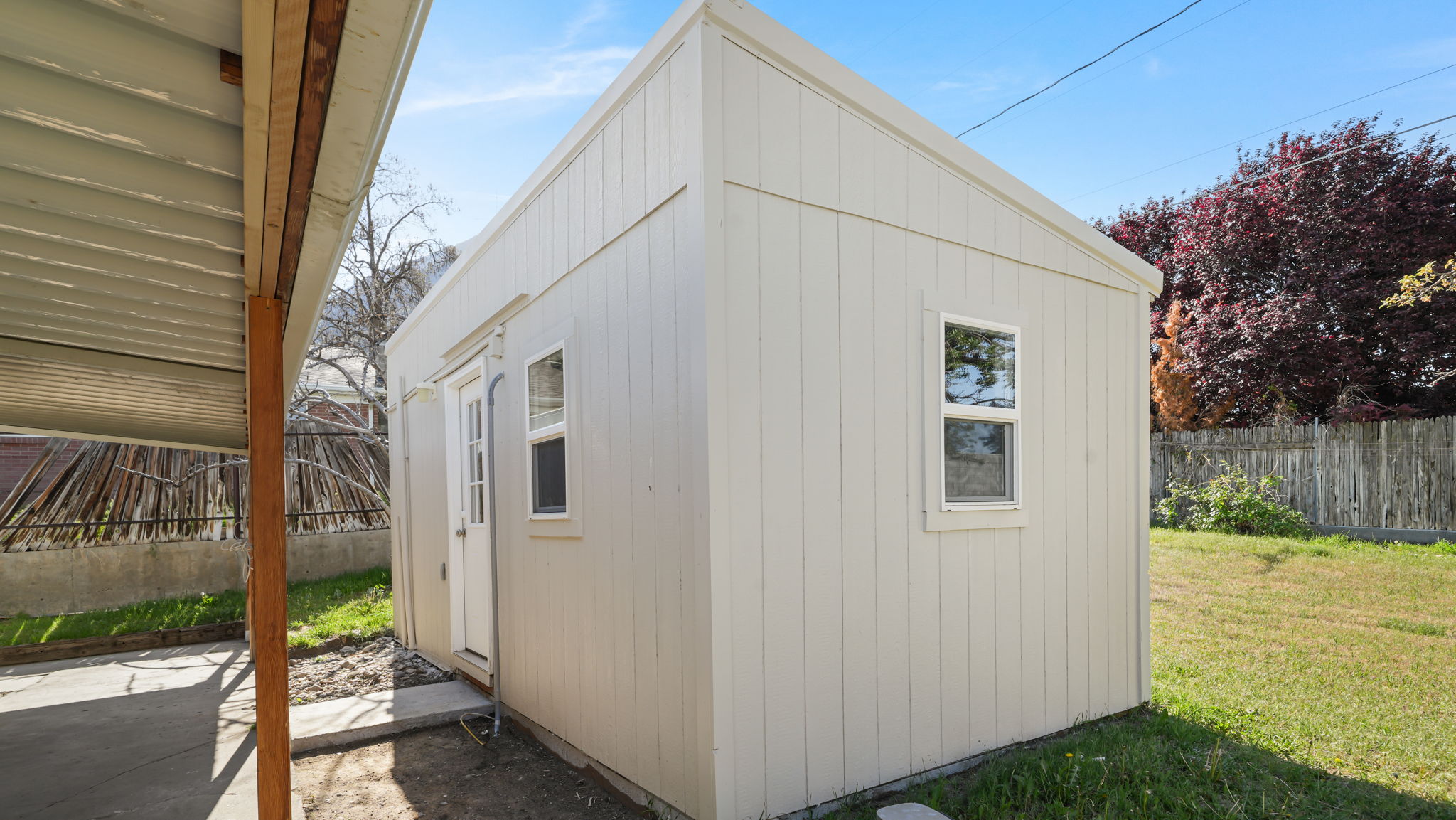 Potential ADU (Buyer to verify with Provo City) Detached auxiliary building featuring light-colored vertical siding, a single entry door, and two windows