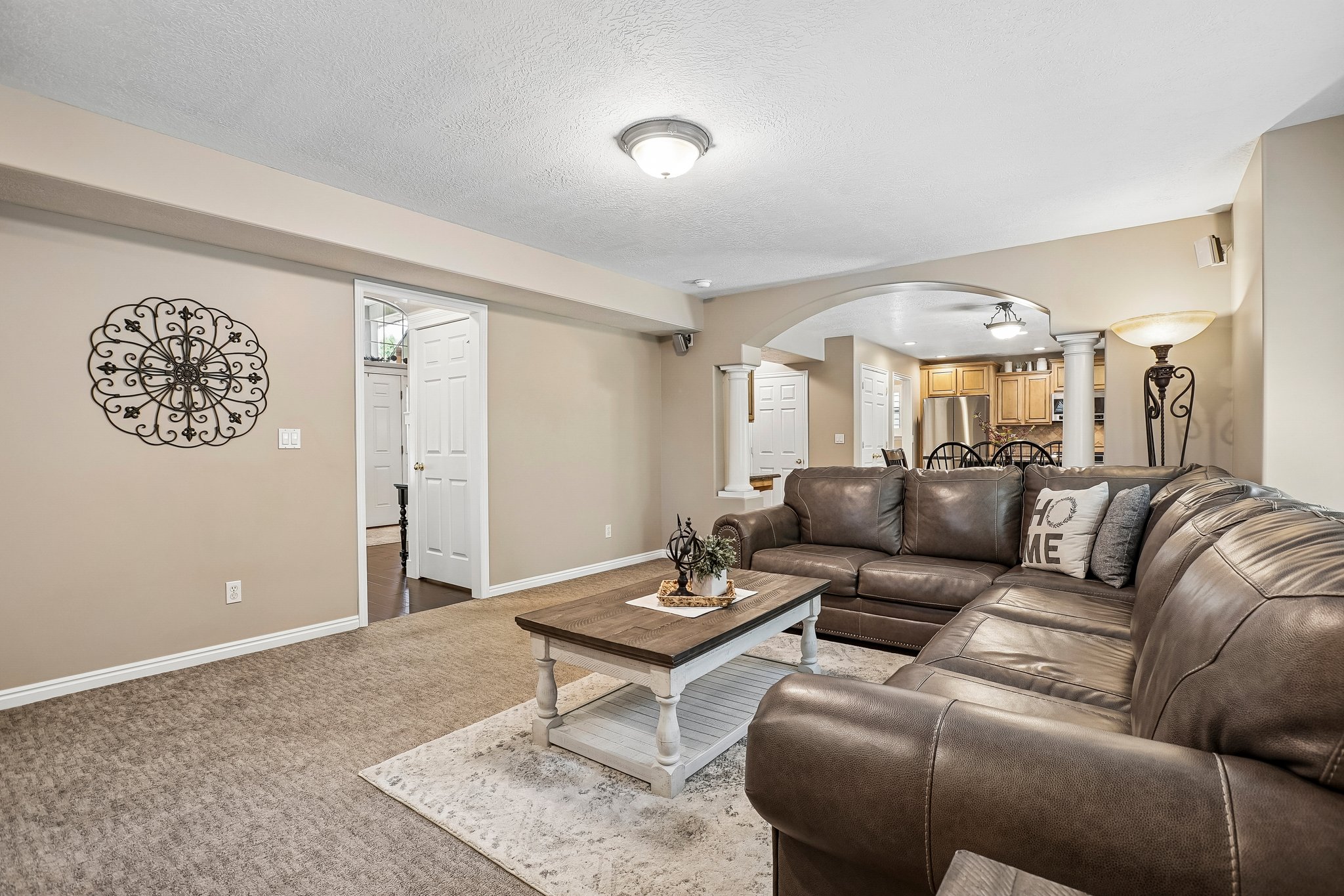 Carpeted living area with recessed lighting, an arched entryway, and a full-light door