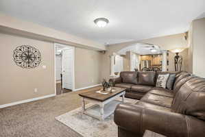 Carpeted living area with recessed lighting, an arched entryway, and a full-light door