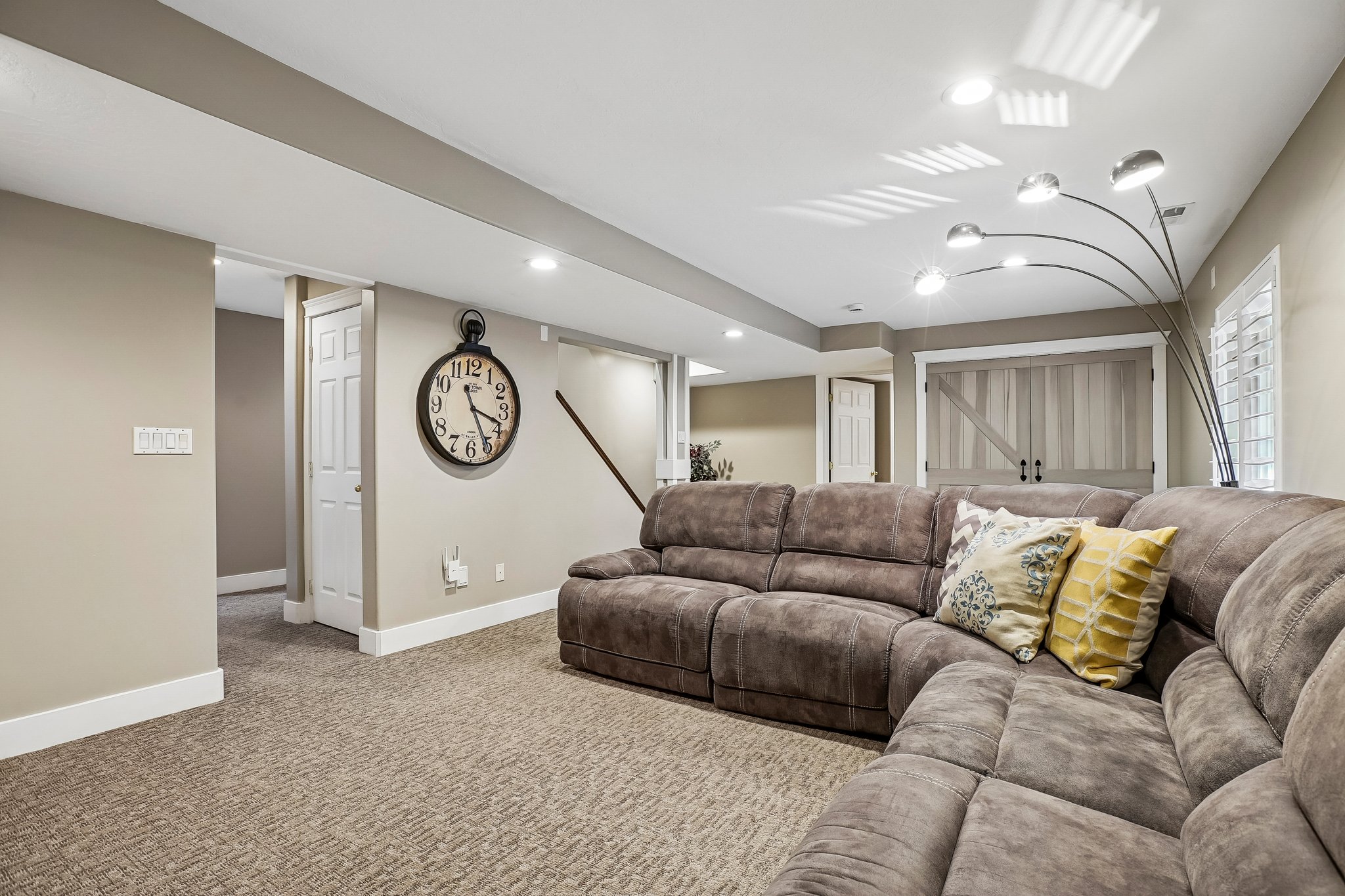 Carpeted recreation room featuring recessed lighting, a barn door, white baseboards, and neutral wall paint