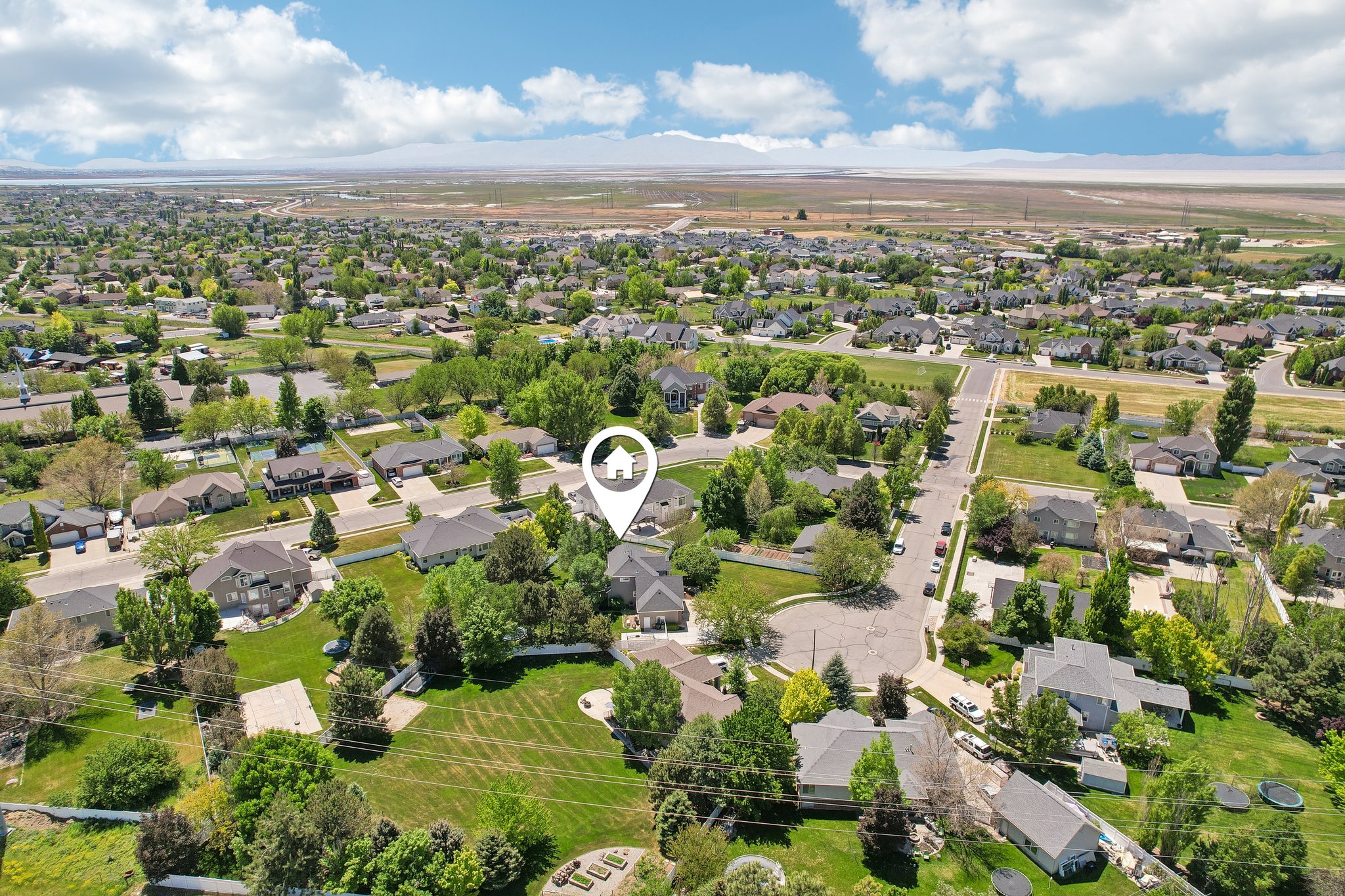Expansive aerial view showcasing a neighborhood with mature trees and established residential properties
