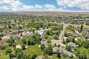 Expansive aerial view showcasing a neighborhood with mature trees and established residential properties