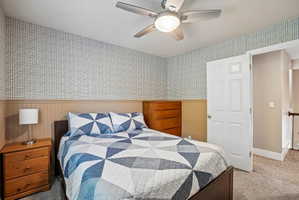 Room featuring textured wallpaper, beadboard wainscoting, and carpet flooring