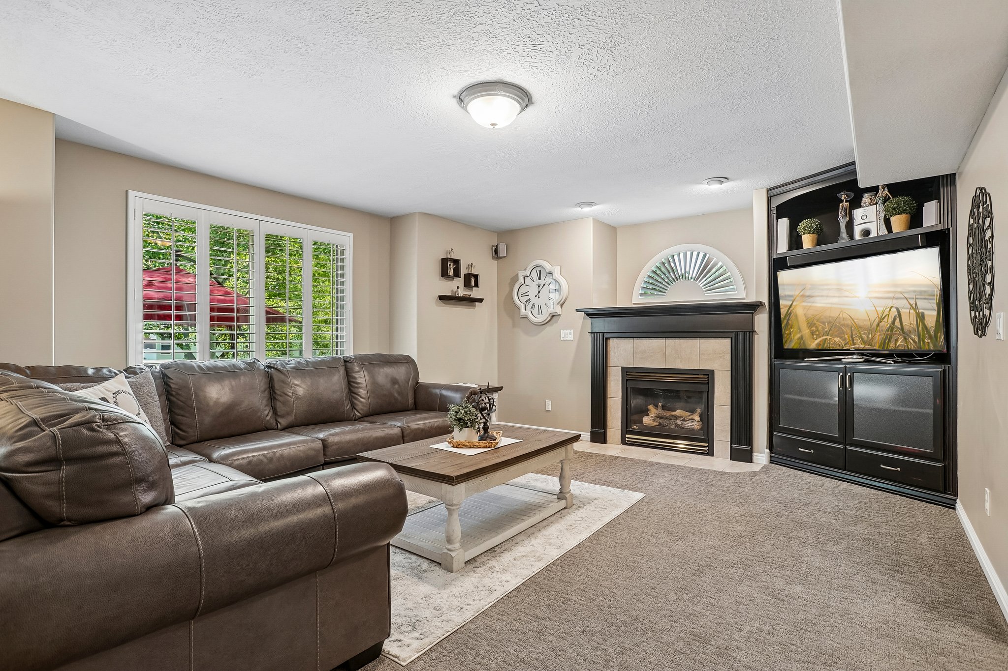 Spacious living area featuring neutral carpeting and light beige walls