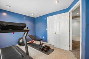 Versatile room featuring plush carpet flooring, recessed lighting, and a bi-fold closet door