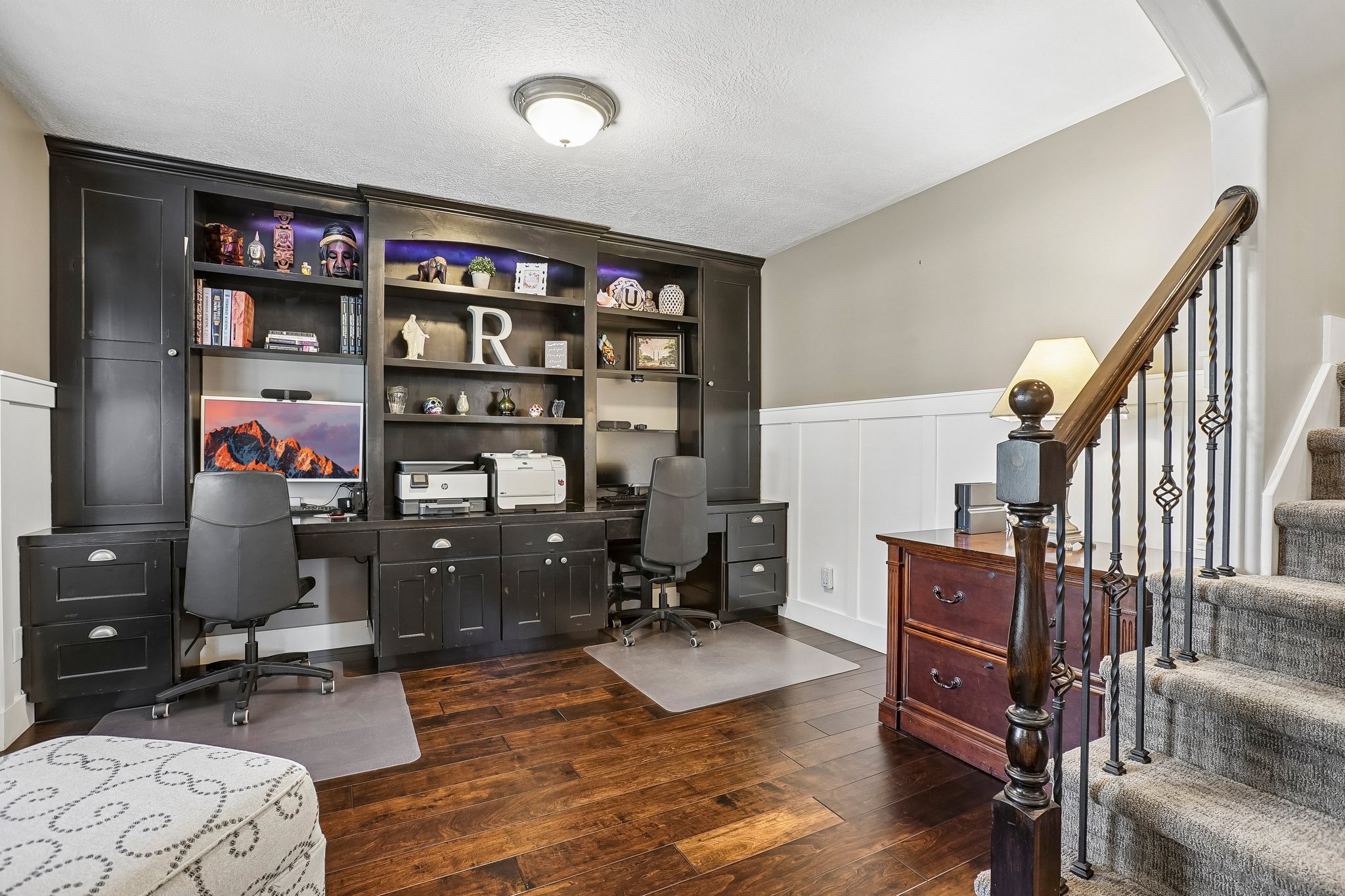 Dedicated office space featuring built-in cabinetry and shelving with integrated lighting