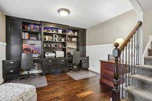 Dedicated office space featuring built-in cabinetry and shelving with integrated lighting