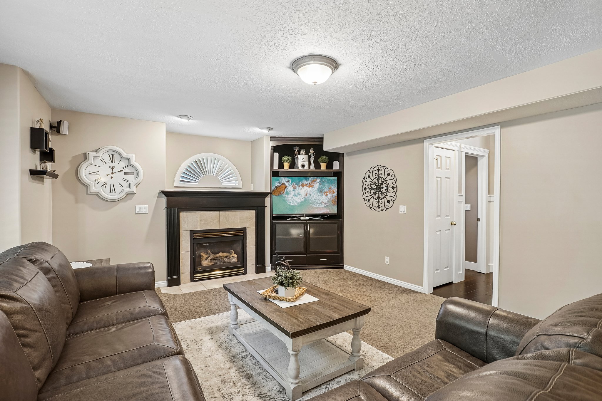Carpeted living area featuring a fireplace with a dark wood mantel and tile surround, built-in shelving, and recessed lighting