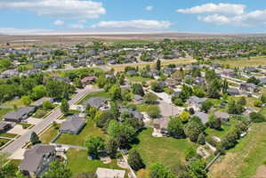 Aerial perspective showcasing a residential neighborhood with detached homes, mature trees, and paved streets