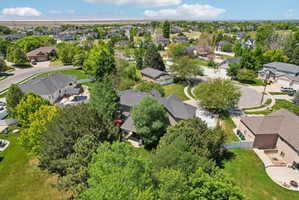 Expansive residential neighborhood featuring numerous properties, mature trees, and a distant mountain range
