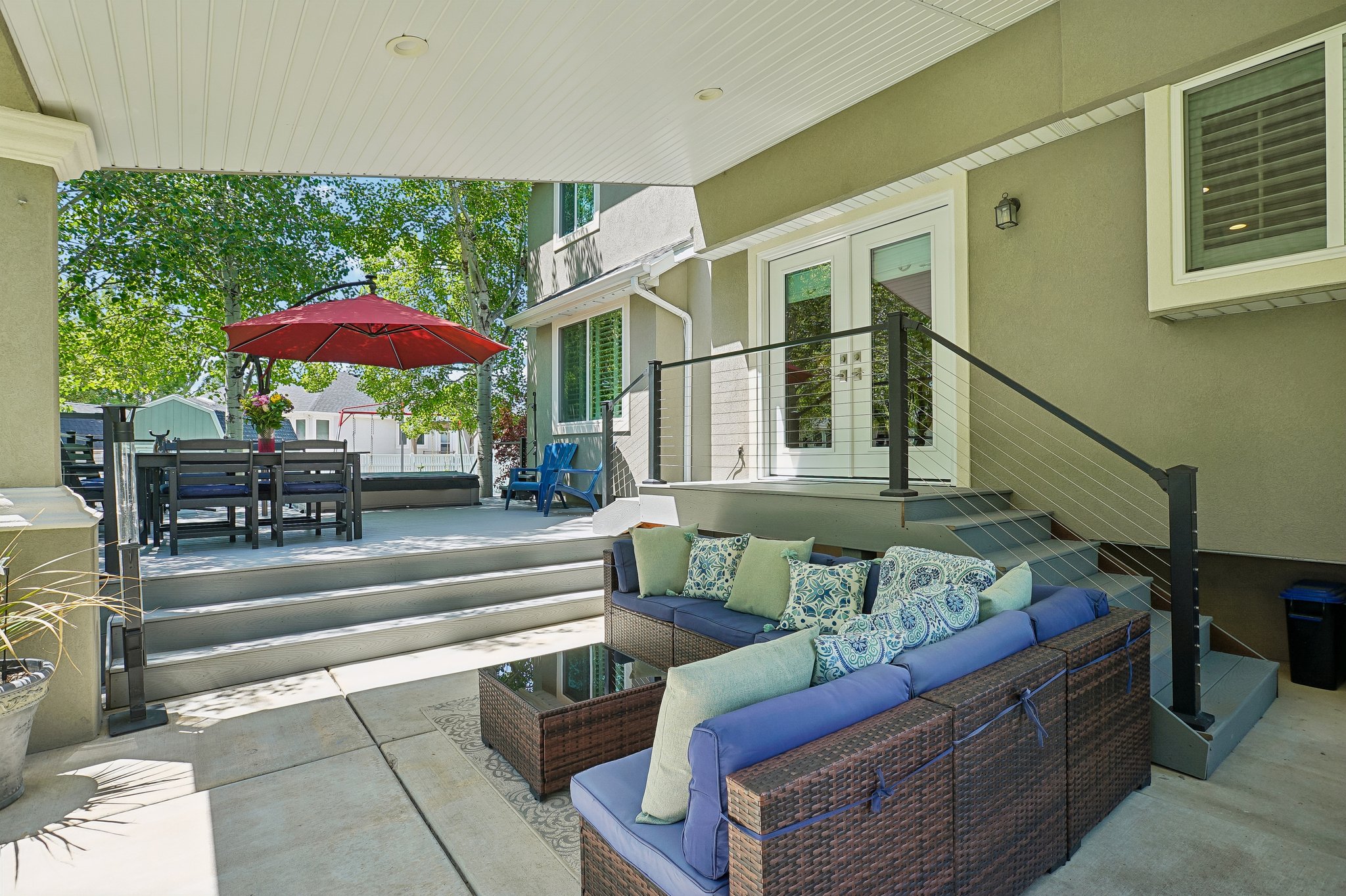 Covered patio featuring a concrete slab and a tiered composite deck