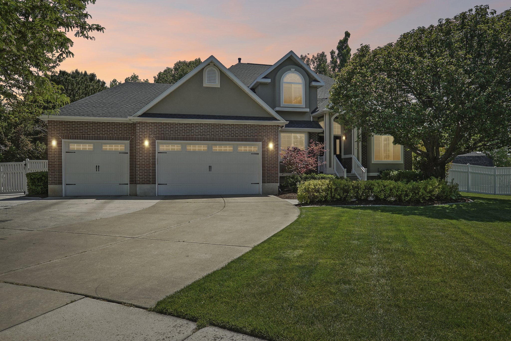 Brick and siding exterior featuring a two-car garage with carriage-style doors