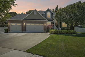 Brick and siding exterior featuring a two-car garage with carriage-style doors