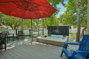 Spacious outdoor deck featuring a built-in hot tub, composite decking, and a black railing system