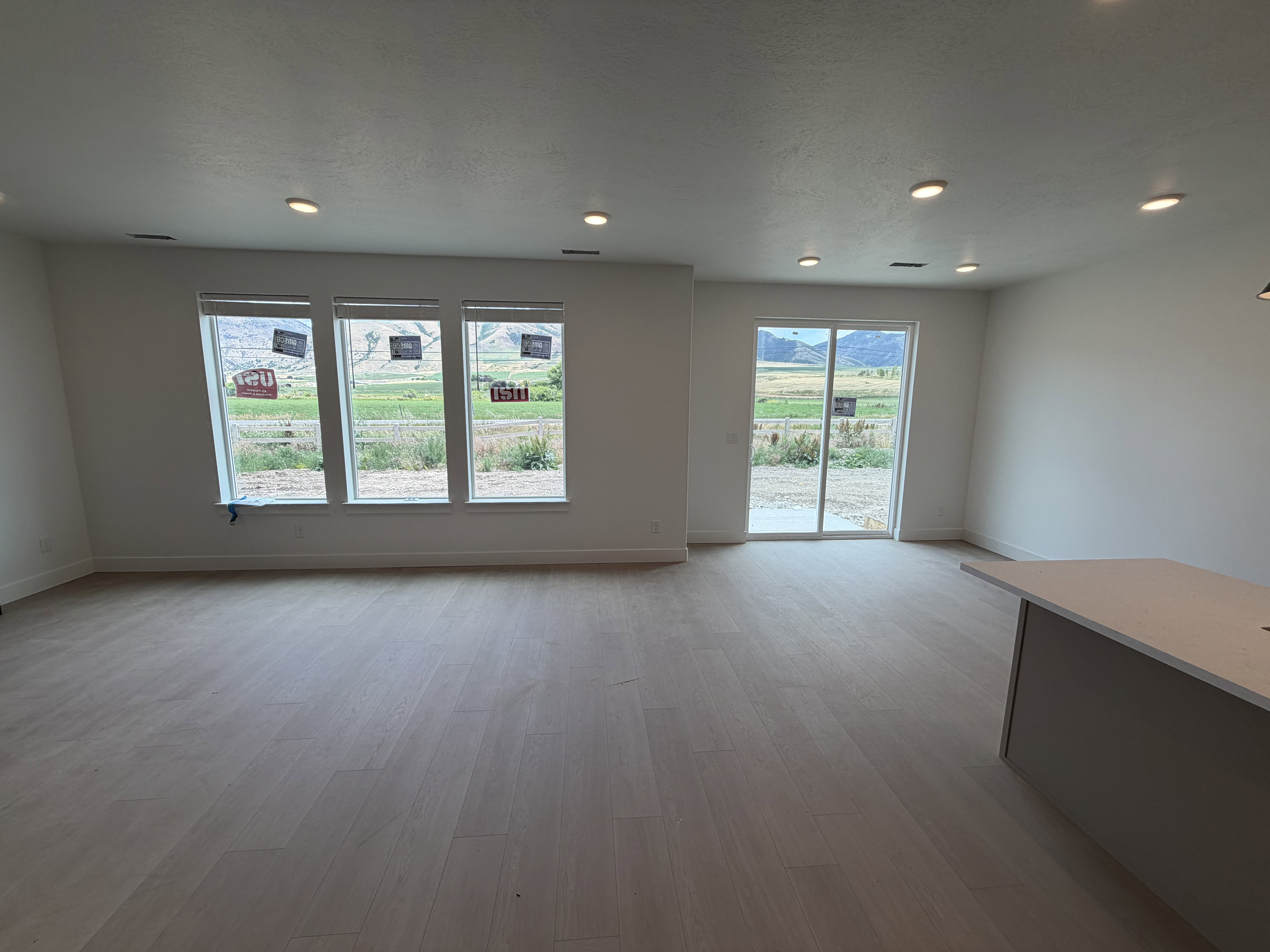 Spacious interior featuring light wood-finish flooring, recessed lighting, and white baseboards