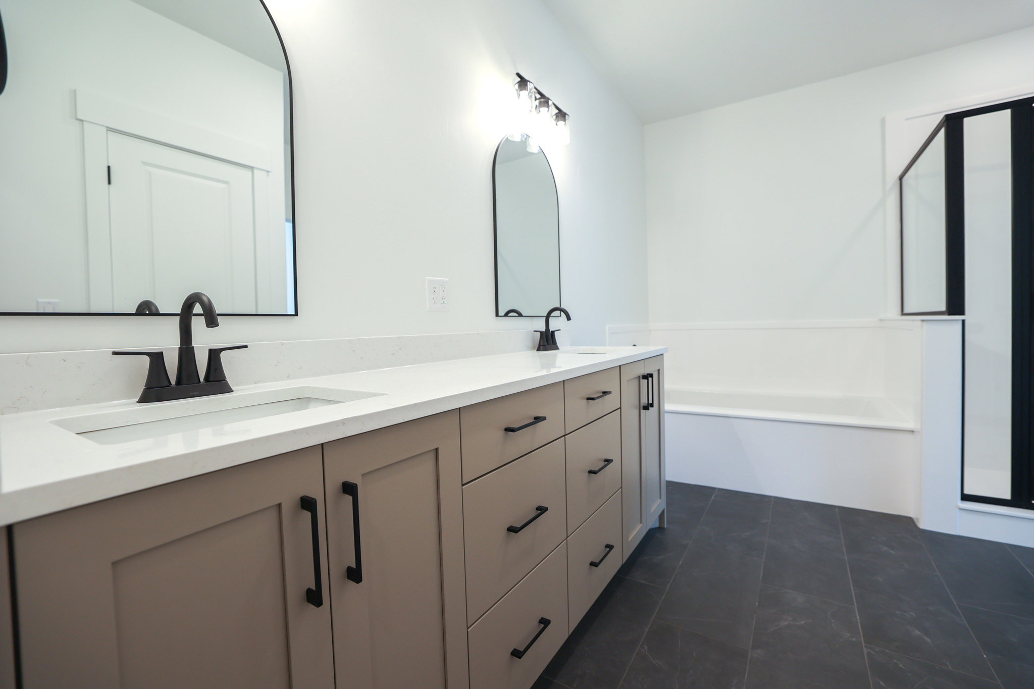 Spacious bathroom featuring a double vanity with light-toned cabinetry and white countertops
