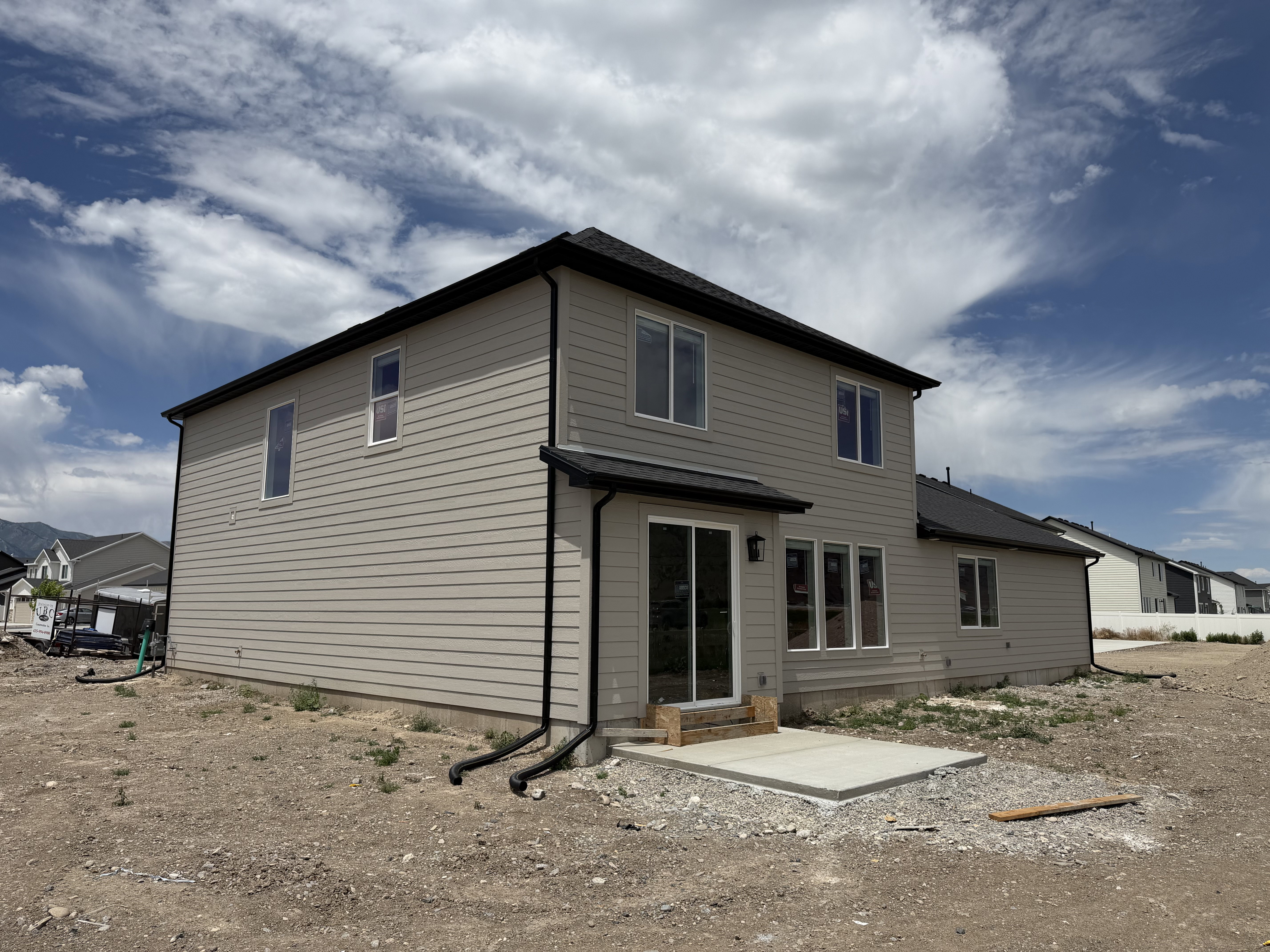 Two-story residence featuring light gray horizontal siding and a dark shingle roof
